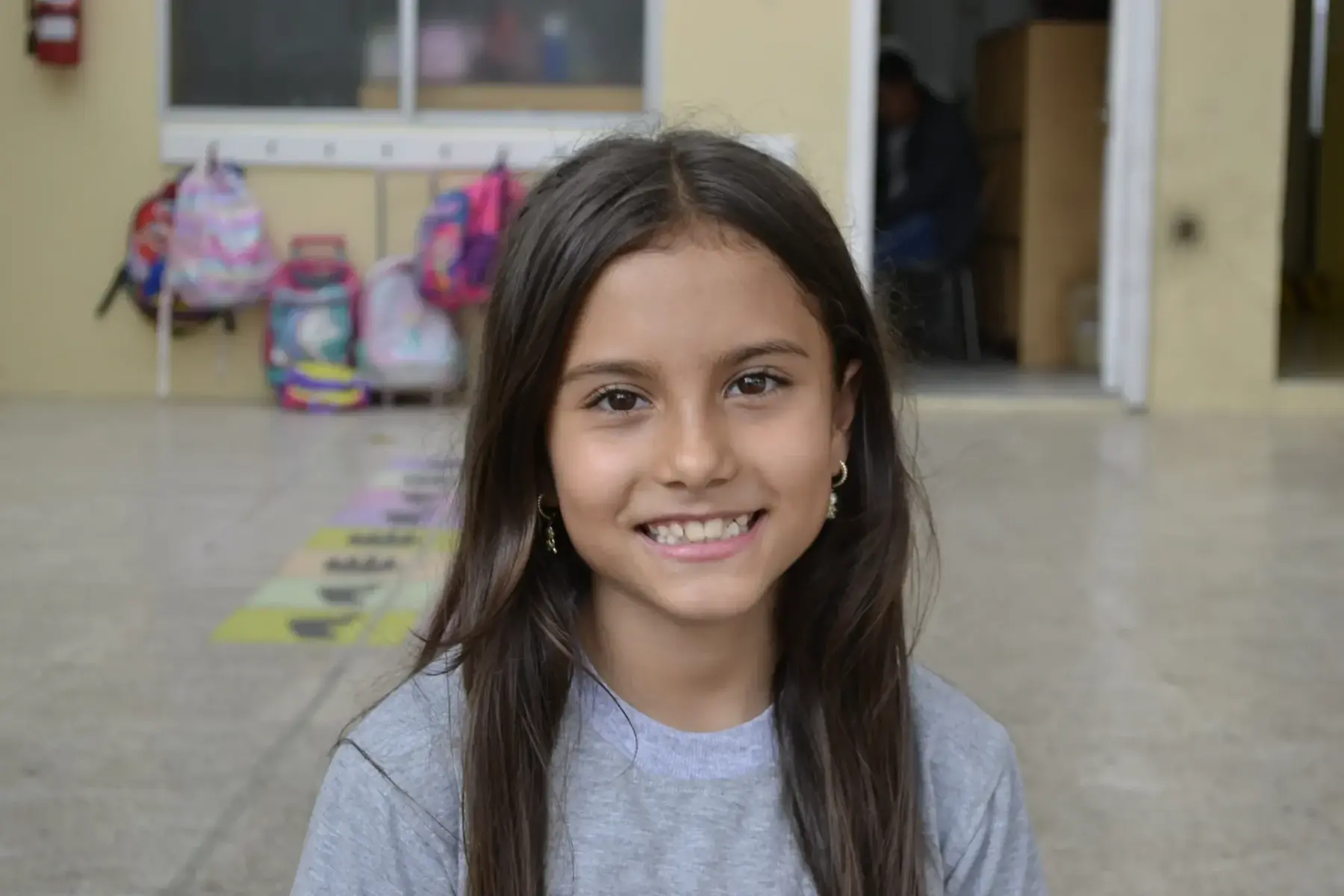Estudiante de Punto de Partida sonriendo en el patio escolar